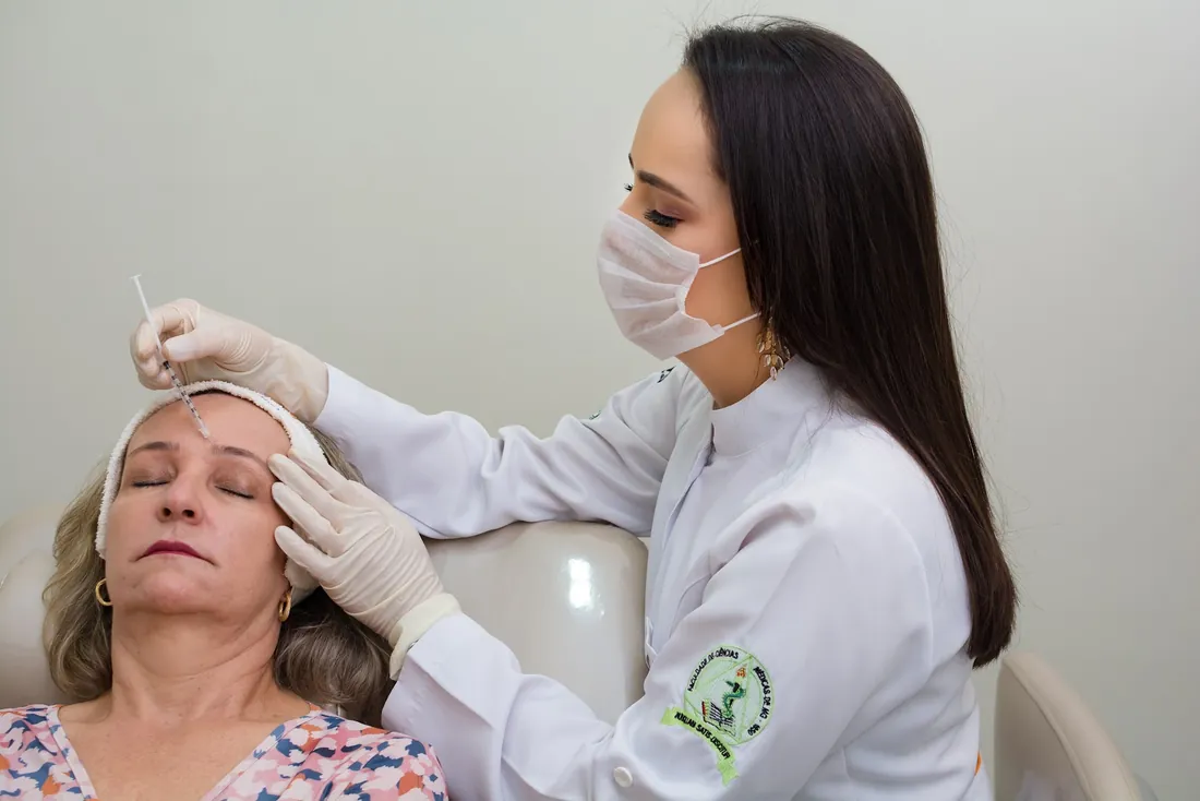 Dra. Lorena, de máscara e luvas, durante um procedimento facial